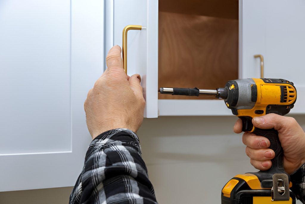 close-up of a man installing a kitchen cabinet handle